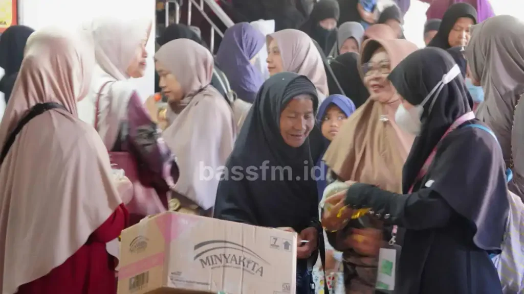 seorang ibu tua menerima minyak dari fasilitator qurrota a'yun