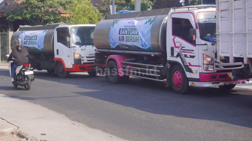 2 truk pengangkut air bersih berjajar di jalan